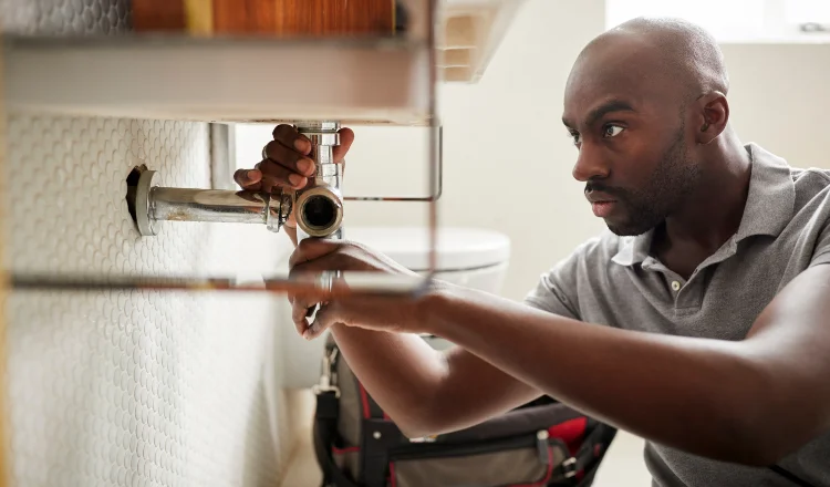 a male plumber fixing a pipe connection from TMK Plumber Austin in Austin, TX Plumber near me
